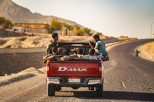 Highway along the Red Sea, Egypt; August 2023: Group of men getting a ride in the back of a pick-up