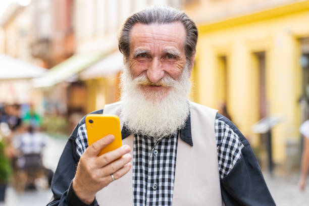 istock Elderly man use smartphone typing text messages browsing internet finishing work looking at camera 1634187096