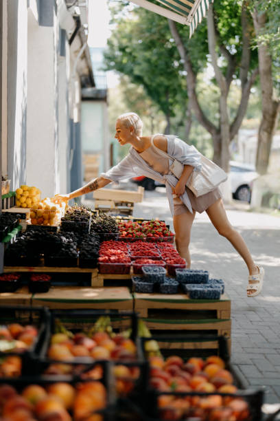 istock Woman Shopping for Fresh Fruit at a Sidewalk Stand 1634192930