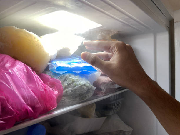 istock Freezer. Hand reaching out to get food from freezer 1634257963
