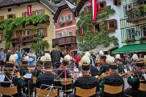 Hallstatt, Austria - July 1, 2023: Concert of the national orchestra on the main square. The musicians are dressed in festive colorful costumes. Famous old town of Hallstatt, Upper Austria.