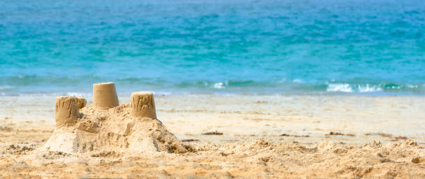 istock Sand Castle - on the beach by the sea coast 1634291629