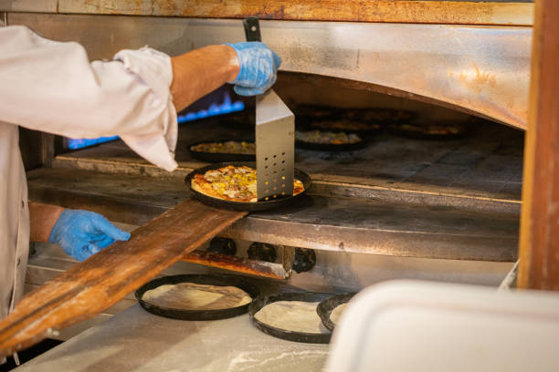 istock Pizza chef preparing pizza in restaurant oven 1634299380
