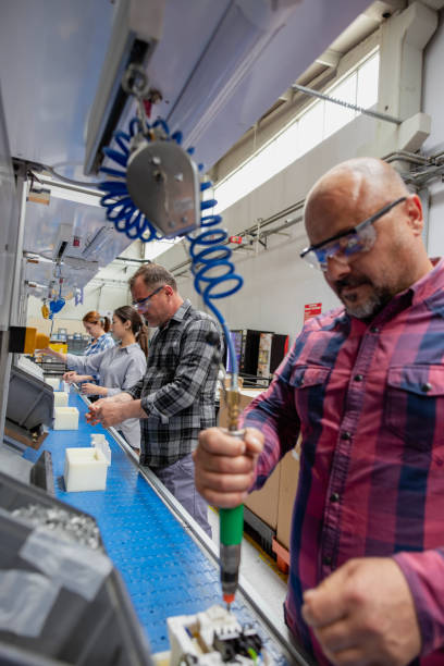 group of workers working on the production line in factory - electric plug electricity women power imagens e fotografias de stock