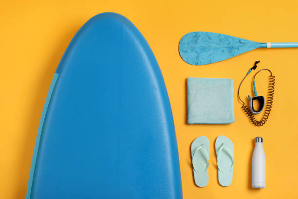 istock Flat lay composition with SUP board on yellow background. Water sport 1634377553