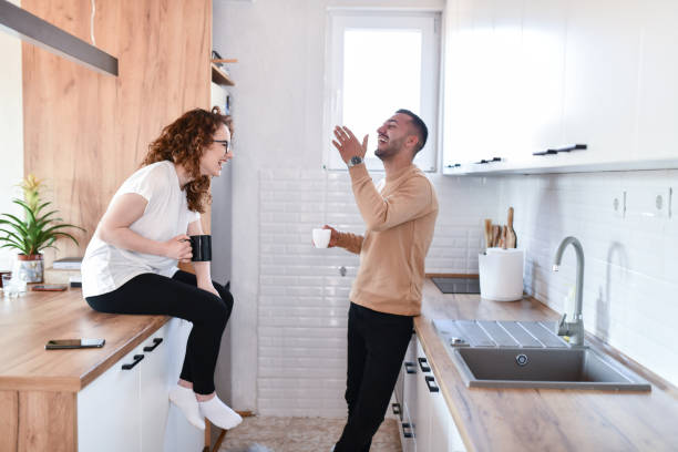 istock Cute Couple Laughing While Enjoying Morning Coffee 1634379317