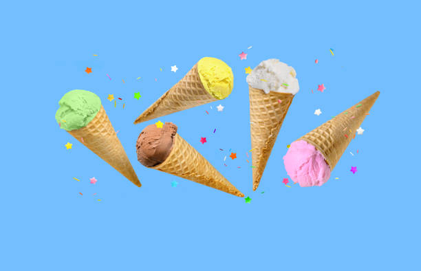 istock Ice cream scoops in waffle cones flying on blue background. 1634383149