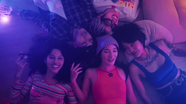 Group of friends lying on the floor in a party room together Look at the lights and have fun chatting.