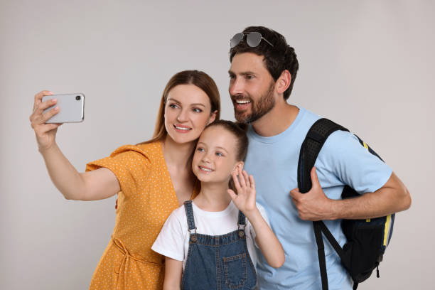 istock Happy family taking selfie on light grey background 1634425475