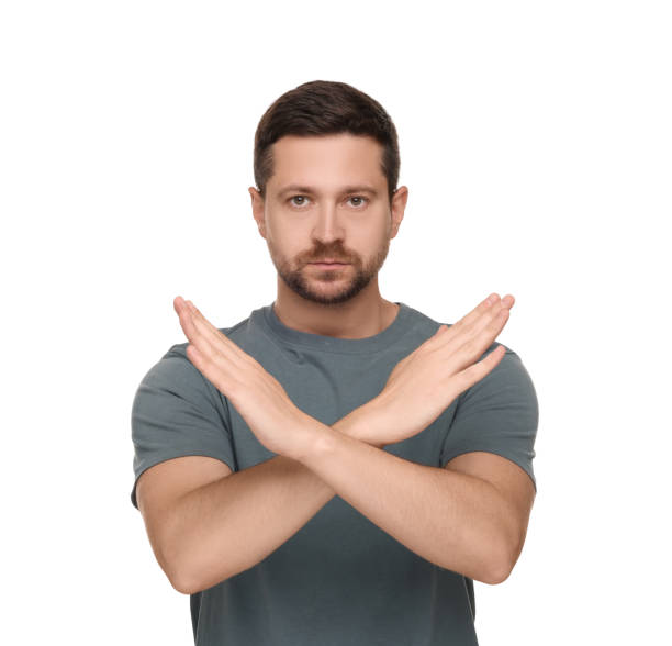 istock Handsome man with crossed hands isolated on white. Stop gesture 1634426292