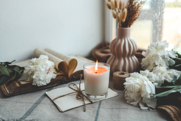 istock Burning candle and white peonies, vintage aesthetic 1634430761