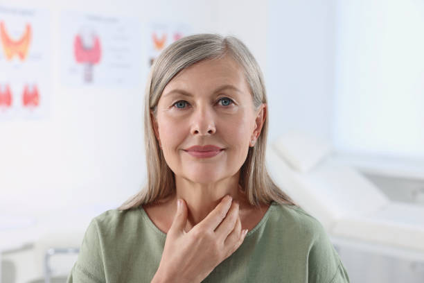 istock Endocrine system. Senior woman doing thyroid self examination indoors 1634439318