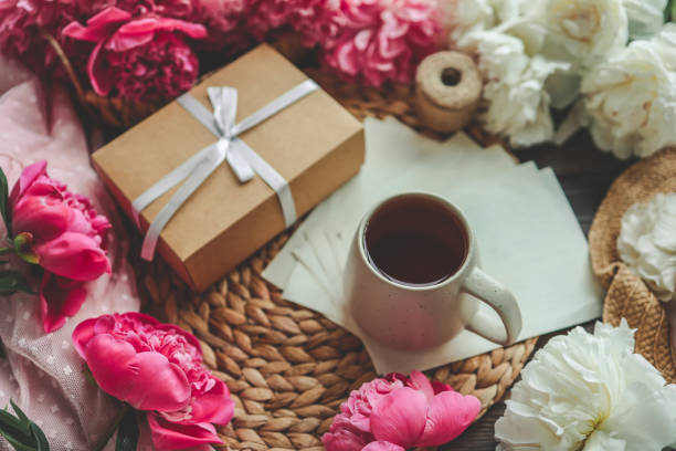 istock Beautiful spring composition, good morning concept. Cup of tea, peonies, gift box 1634439322