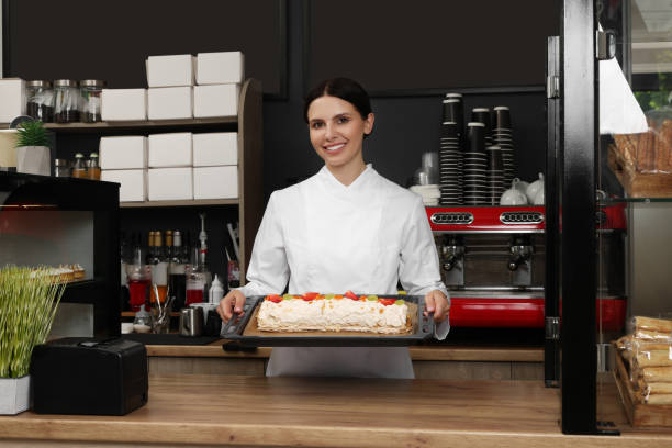 istock Happy baker presenting delicious cake with strawberries in cafe 1634442508