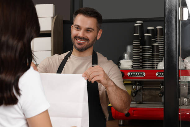 istock Worker giving to customer package with fresh pastries in cafe 1634444152