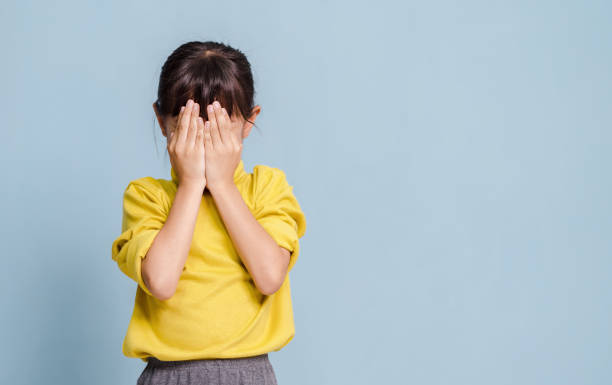 istock A little girl is covering her face with her hands. 1634455265