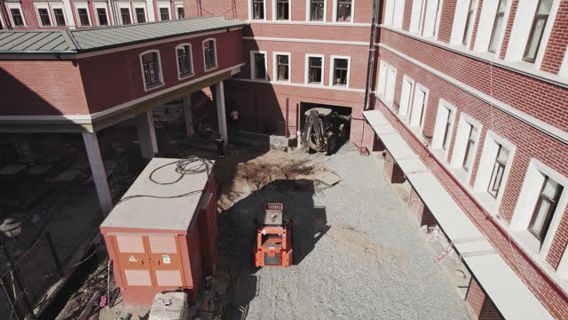 Construction team renovating public building with machinery