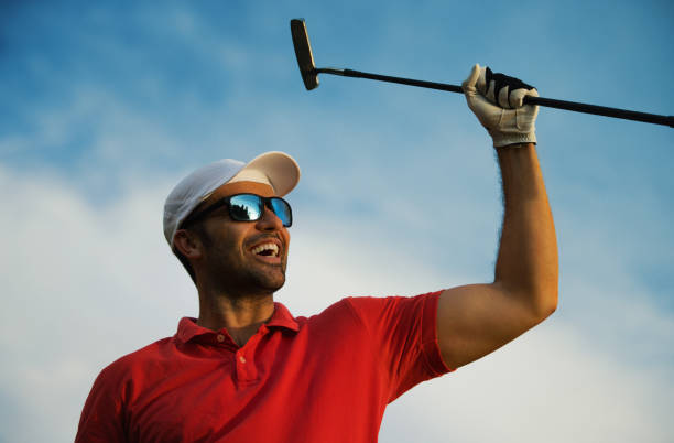 young man celebrating win at a golf course - golf golf swing putting cheerful imagens e fotografias de stock