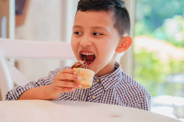 istock Little kid trying to eat a cupcake 1634652834