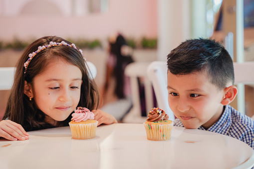 Children talking at the bakery while eating their cupcakes