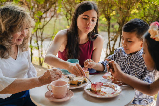 Multi-generation family talking and having fun in a cafe while drinking coffee stock video stock photo