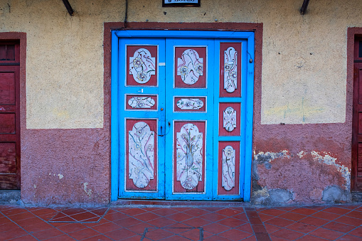 A painted traditional ornate front door in the city of Cuenca