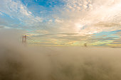 golden gate bridge under heavy fog in a sunny day at golden hour