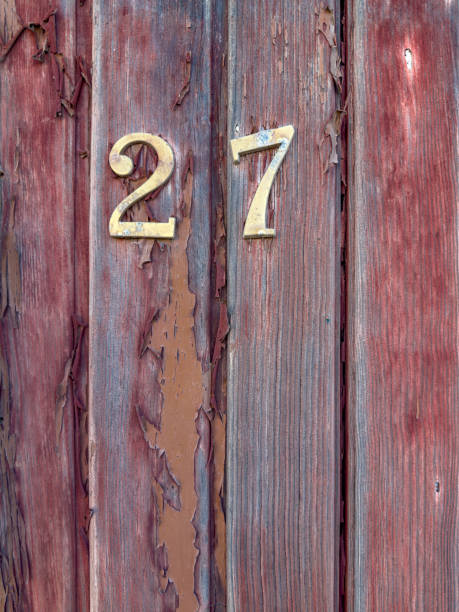 istock Number 27 on red painted old wooden wall. 1634727373