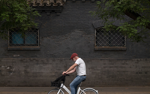 Adult man on bike on street. Beijing, China
