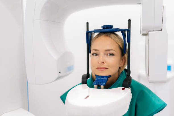 widok z przodu młodej pacjentki stojącej w dentystycznym ekspercie do radiografii stomatologicznej w nowoczesnej klinice stomatologicznej. pojęcie stomatologii, medycyna - x ray equipment x ray machine radiation zdjęcia i obrazy z banku zdjęć