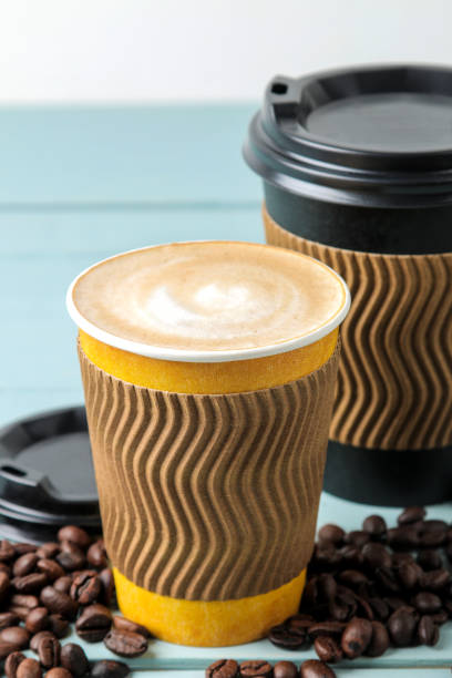 istock Paper cups with cappuccino and coffee beans on a blue table. coffee to go 1634741811