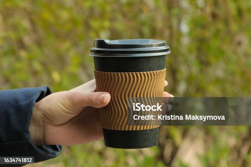 istock The girl holds a paper cup for hot drinks in her hands. coffee to go 1634741812