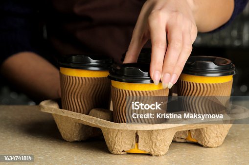 istock Barista girl holding paper cups for hot drinks. coffee to go 1634741814