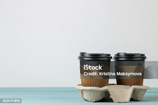 istock Paper cups with coffee on a blue table. coffee to go 1634741815