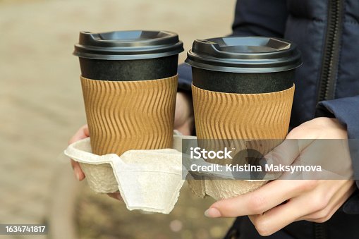 istock The girl holds paper cups for hot drinks in her hands. coffee to go 1634741817