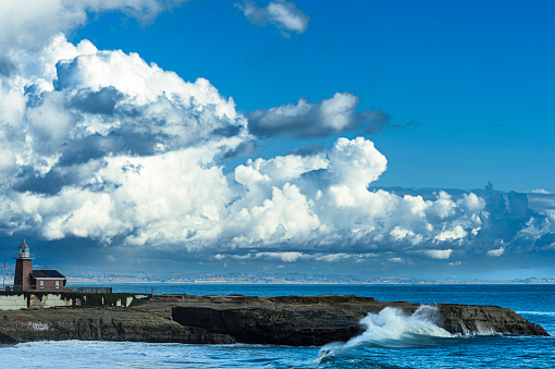 Santa Cruz lighthouse in the late afternoon, with water covered  beach in foreground.\n\nTaken in Santa Cruz, California