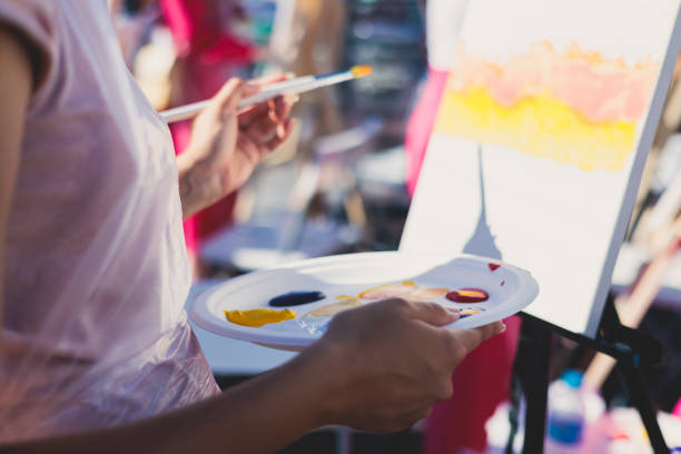istock Process of drawing, group class of talented students with painting easels and canvases during lesson of watercolour painting outdoors, drawing class 1634806867