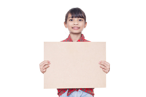 Young Asian girl standing holding a empty brown wooden board isolated on white background with clipping path. Education concept. Copyspace.