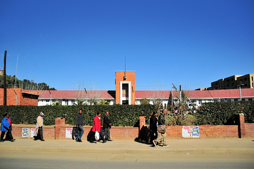 Maseru, Lesotho: people walk along Kingsway, in front of the Queen Elizabeth II Hospital - built in 1957 during the British protectorate - colonial architecture.