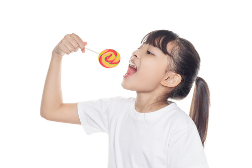 Young Asian girl holding lollipop candy isolated on white background with clipping path