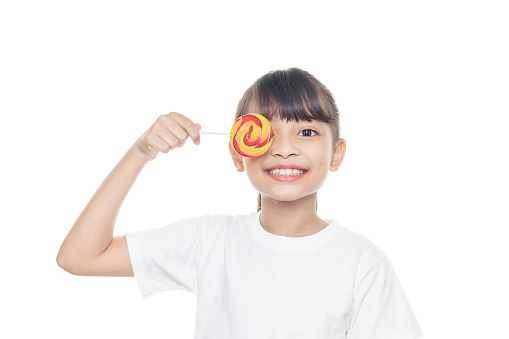 Young Asian girl smiles and holding lollipop candy isolated on white background with clipping path.