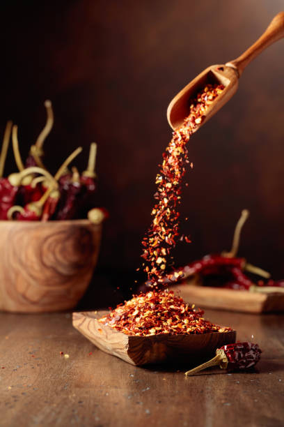 istock Chilli flakes are poured into a wooden dish. 1634864453