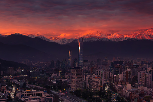 Sunset on a winter day, in the city of Santiago, view of the Costanera Center with the Andes Mountains illuminated by the sun in the background
