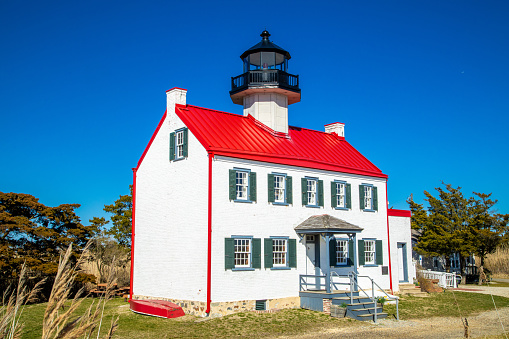 Isolated image of East Point Lighthouse in NJ against a deep blue sky