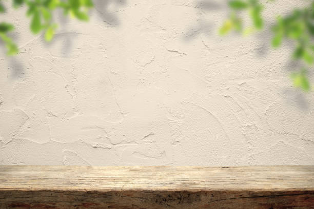 istock Empty wooden table on beige wall concrete texture rough. Counter display concept 1634894735