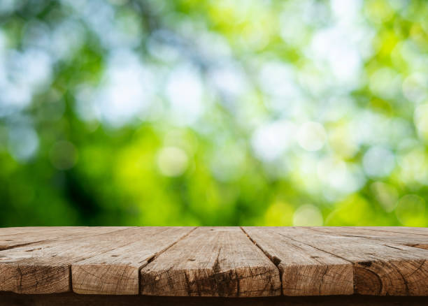 istock Empty wooden table are placed outdoors on green bokeh from natural leaves and sunlight. Counter display concept 1634896363