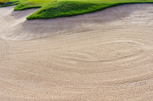 Man in a sand trap on a golf course in West Palm Beach Florida, Okeeheelee park
