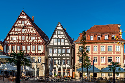 Ensemble of three old patrician houses on the market square in the historic old town of Schwäbisch Gmünd with street café in the foreground