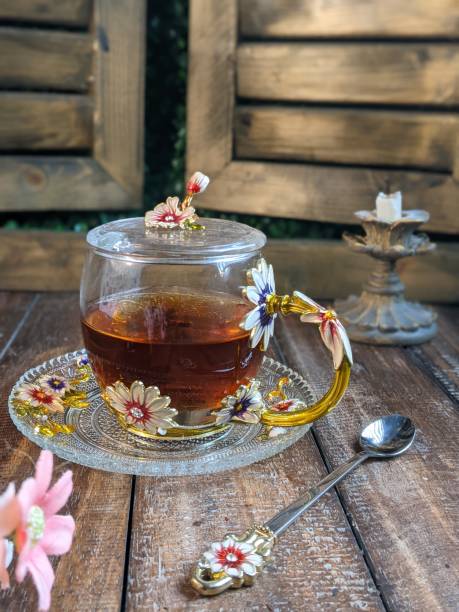 A Cup of freshly brewed black tea,escaping steam,warm soft light, darker background.