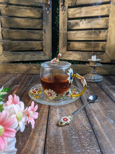 A Cup of freshly brewed black tea,escaping steam,warm soft light, darker background.